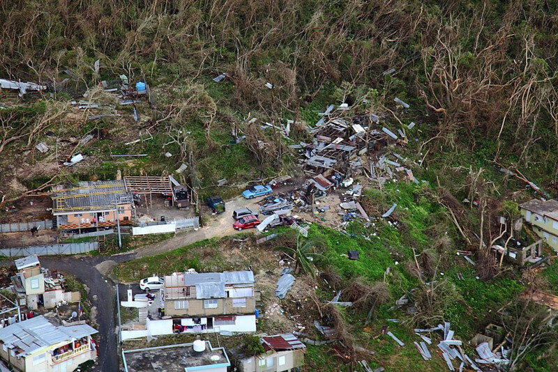 Destroyed homes in Puerto Rico in the aftermath of Hurricane Maria, prompt questions about the appropriateness of travel amidst tragedy.