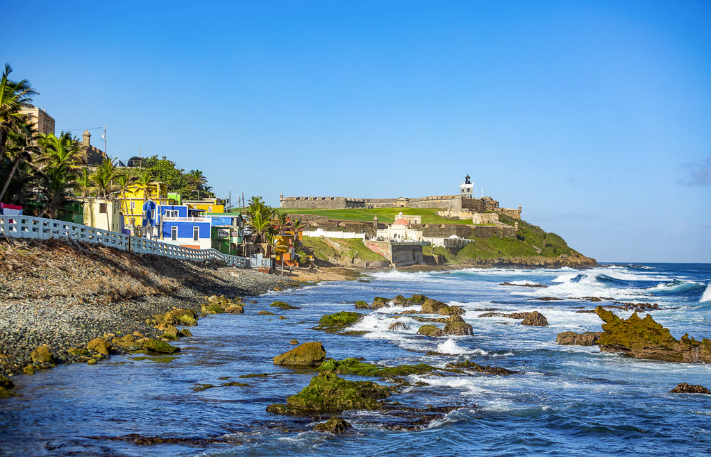 S view of colorful homes along the brilliant blue Atlantic, which will be seen on a Puerto Rico 7 Day itinerary.